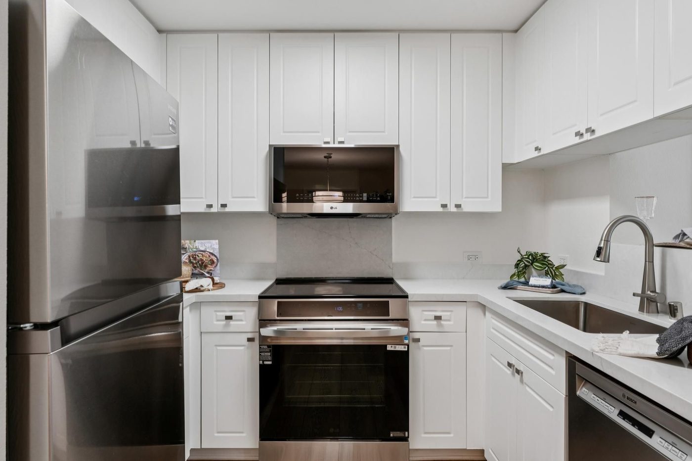 Bright white kitchen with stainless steel appliances and wood floor