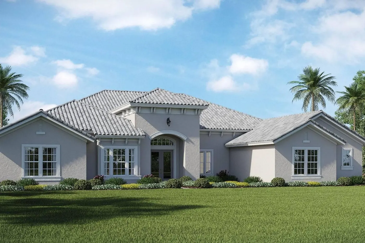 Large gray house with manicured lawn and palm trees under blue sky